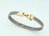un gros plan sur un bracelet en câble muni d'un fermoir en or