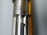 a close up of a gun with a wooden handle on a table