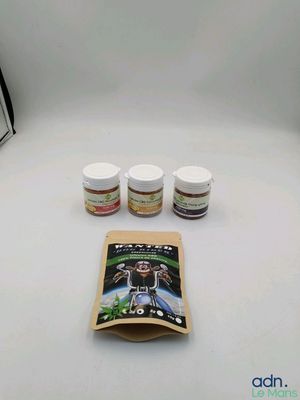 three jars of paint and a book on a table