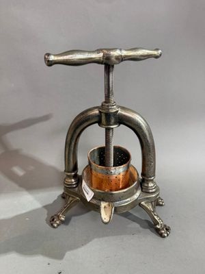 un petit objet métallique muni d'un manche en bois, posé sur un socle