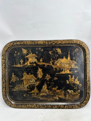 a black and gold tray with a painting on it