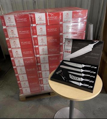 a box of knives on a table in front of a stack of boxes