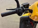 a close up of the handlebars on a yellow motorcycle