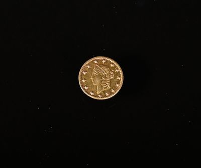 gros plan d'une pièce d'or sur une surface noire