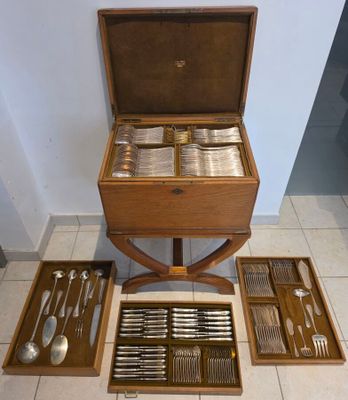 une table en bois sur laquelle sont posés des couverts et un plateau contenant des couverts