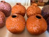 five different colored vases sitting on a table