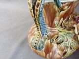 a vase that has a snake on it on a table