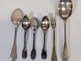 several spoons and forks are lined up on a white surface