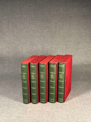 three books are stacked on top of each other on a gray surface