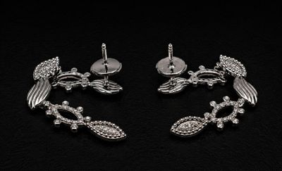 pair of silver plated bird earrings with crystal accents on a black background