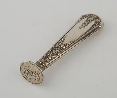 an antique silver spoon on a white surface with a flower design