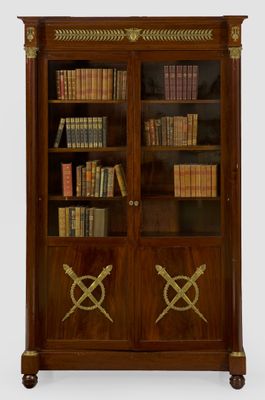 an antique bookcase with two doors and two crossed swords on the doors