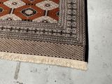 a cat that is sitting on a rug on the floor