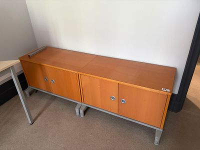 a wooden cabinet with two drawers and a table in front of it