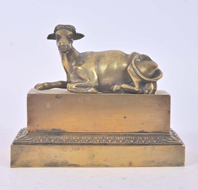 une statue représentant un mouton couché sur une caisse en bois
