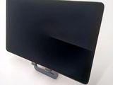 a black monitor sitting on a stand on a white surface