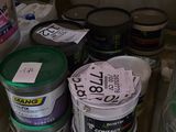 de nombreux seaux de peinture sur les étagères du magasin