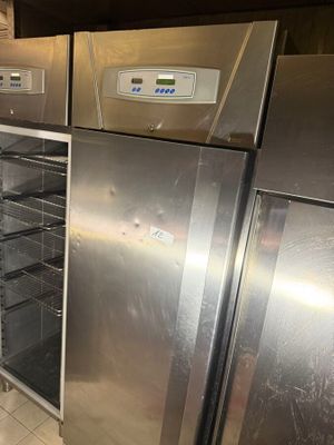 stainless steel refrigerators and freezers in a kitchen with tile flooring