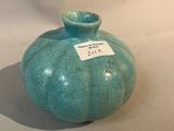un vase bleu muni d'une étiquette, posé sur une table