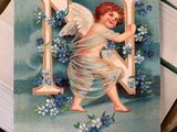 a card with a picture of an angel holding a letter n