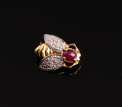 gros plan d'une bague en or avec un rubis et des diamants