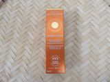 an orange box of sun cream sitting on top of a bamboo mat