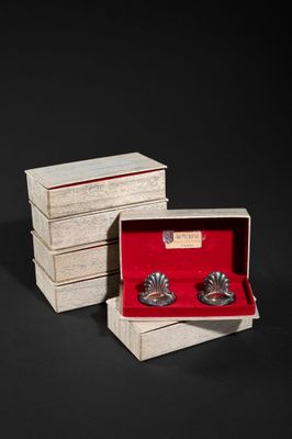 a pair of silver cuffers in a wooden box with red velvet lining