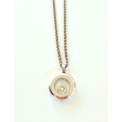 a close up of a necklace on a white surface with a chain
