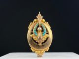 un gros plan d'une bague en or ornée d'une pierre turquoise au centre