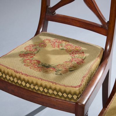 une chaise sur laquelle est posé un coussin et dont le dossier est orné d'un coussin de chaise