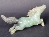 chinese carved jade horse figurine on a black background