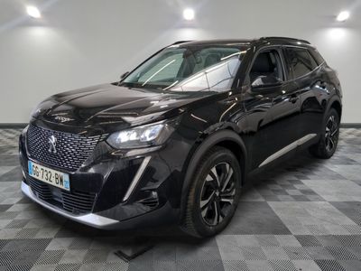 un 4x4 noir garé sur un sol en damier dans un garage
