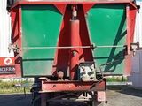 a green and red dump truck that is parked in front of a building