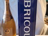 une bouteille de brut posée à côté d'une boîte sur une table
