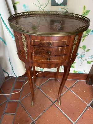 a small wooden table with a glass top on a tiled floor
