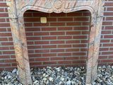 un ancien encadrement de cheminée en marbre avec un mur de briques en arrière-plan