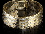 une photo en gros plan d'un bracelet en or sur lequel est posée une montre