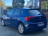 a blue volkswagen e - golf parked in front of a building