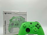 a close up of a green xbox controller with a box in the background