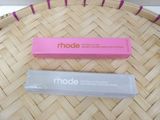 two tubes of made cosmetics sitting on top of a woven basket