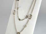 a close up of a necklace on a display on a white surface