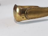 a gold spoon sitting on top of a white table