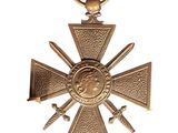 an image of a gold medal with swords and a cross on it