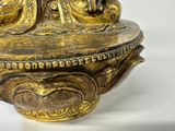 a gold statue of a man and a woman on top of a bowl