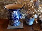 un vase bleu et blanc contenant des fleurs, posé sur une table