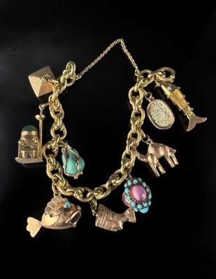 a close up of a gold bracelet with charms on it