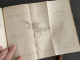 someone is holding an open book with a map on it