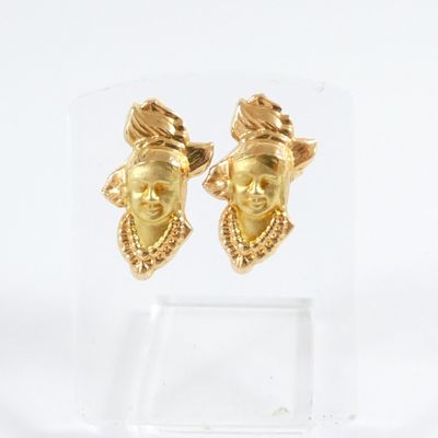 pair of gold tone earrings with a face of a woman