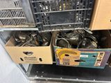 Des boîtes contenant des couverts sont empilées les unes sur les autres sur une étagère