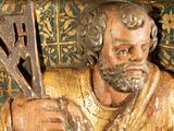 a statue of a man holding a cross and a sword